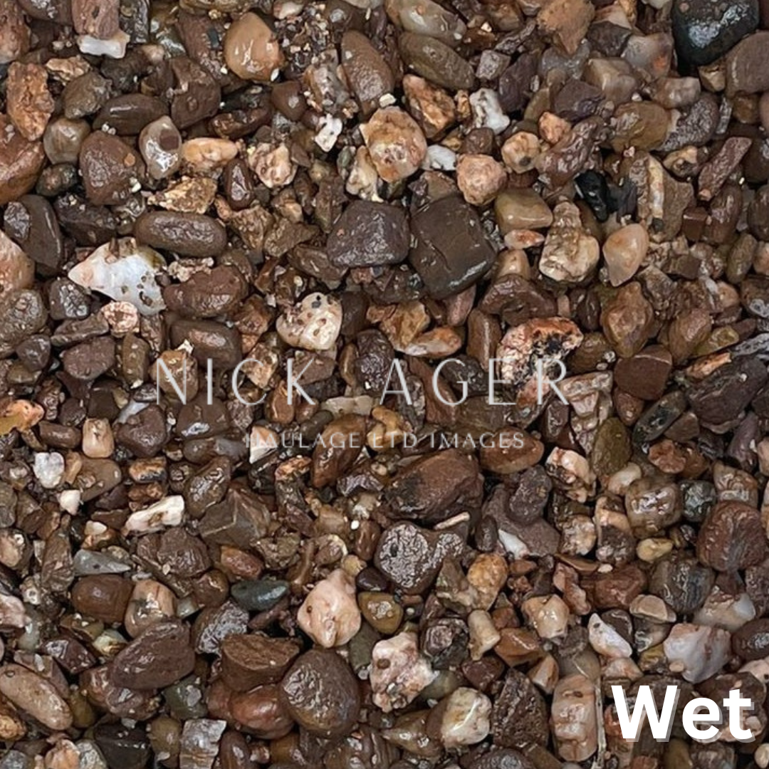 Close-up of wet gravel stones displaying a mix of earthy colours and textures, including browns, creams, and greys.