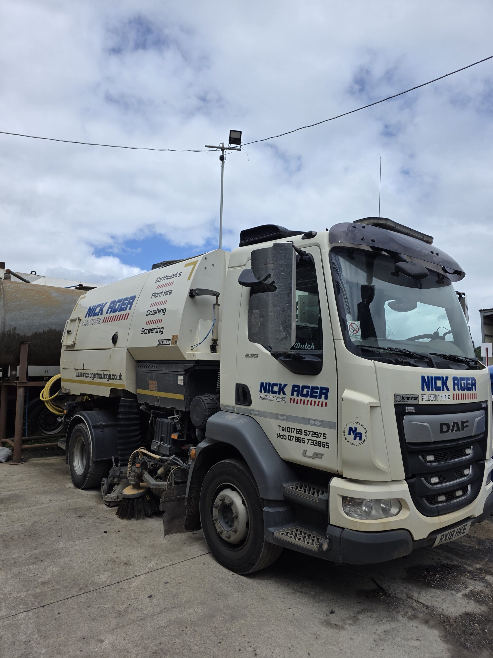 Nick Ager Plant Hire Road Sweeper A road sweeper vehicle belonging to Nick Ager Plant Hire, parked on a concrete surface with cloudy skies in the background.