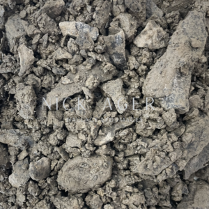A detailed close-up image of crushed earth material, featuring various sizes of grey and brown rocky fragments with a textured surface.
