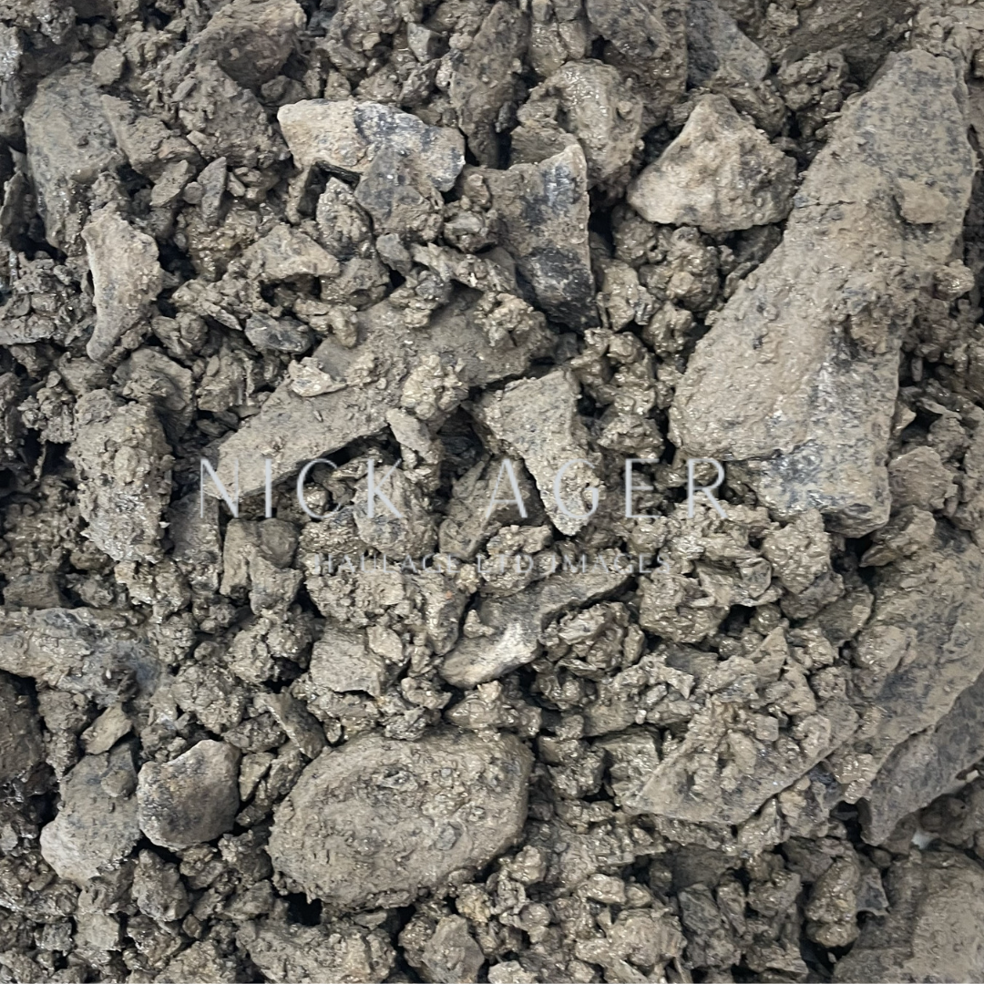 A detailed close-up image of crushed earth material, featuring various sizes of grey and brown rocky fragments with a textured surface.