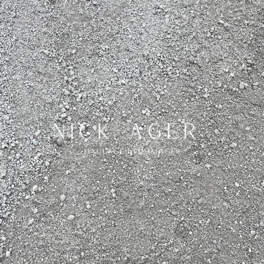 A textured surface of grey gravel with small stones and pebbles scattered throughout.
