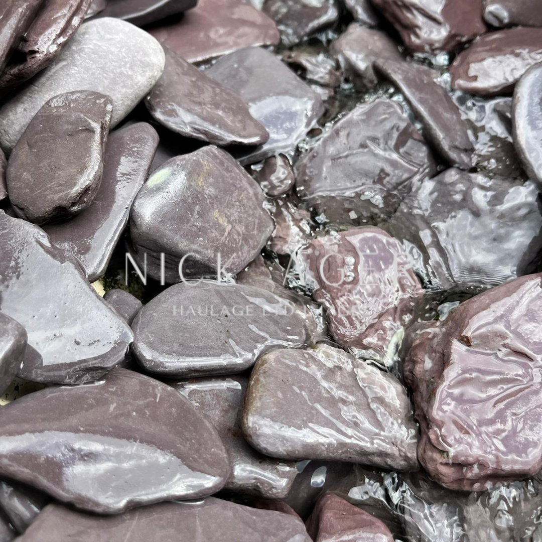 A close-up image of smooth, rounded purple pebbles partially submerged in clear water, showcasing various shapes and textures.