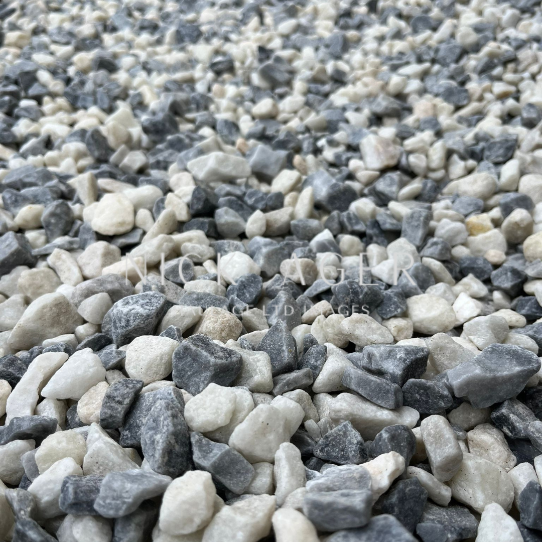A close-up view of assorted decorative gravel stones in grey, white, and light beige shades, showcasing their varied textures and sizes.