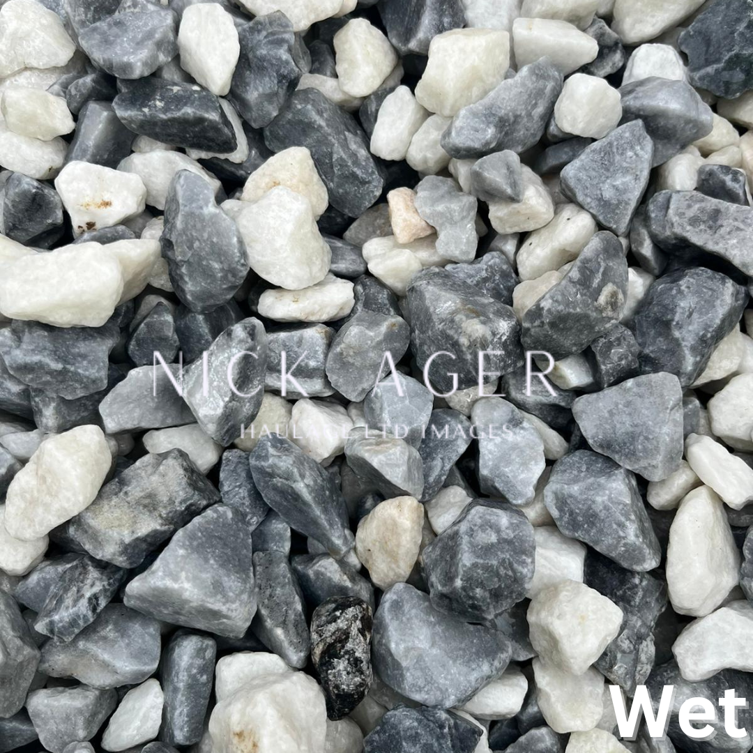 Close-up view of wet decorative stones in various shades of grey and white, showcasing their natural textures and colours.