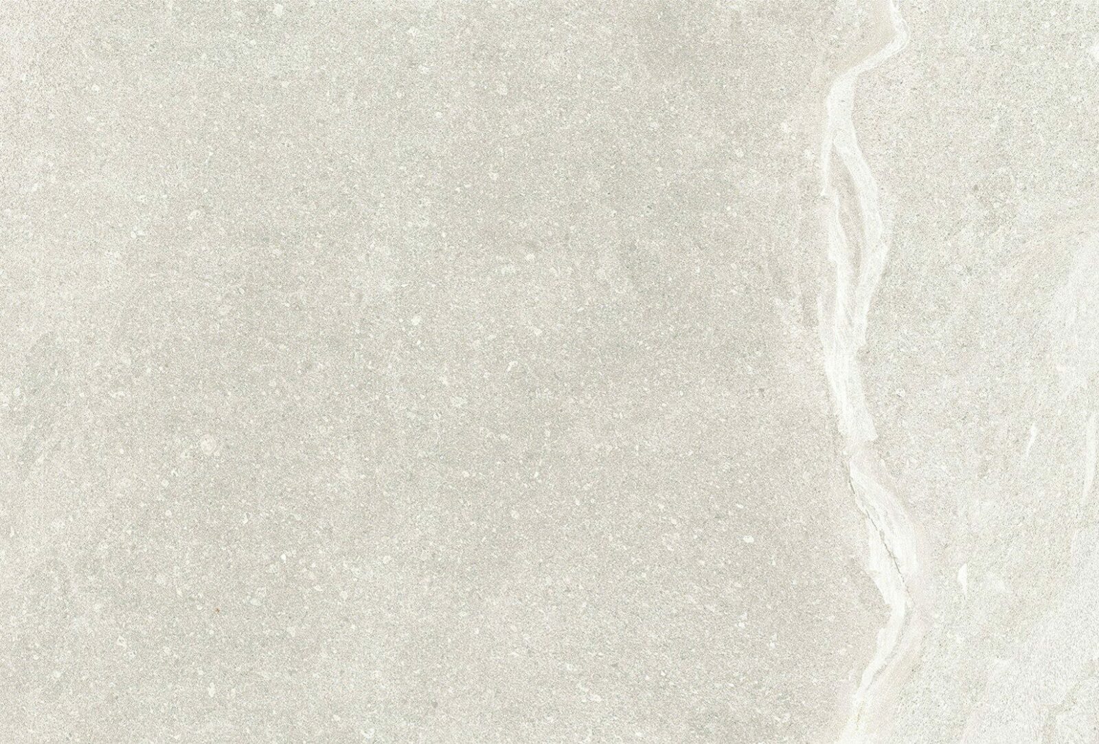 A smooth, light grey stone surface with subtle texture and a faint white vein running through it, ideal for design inspiration.